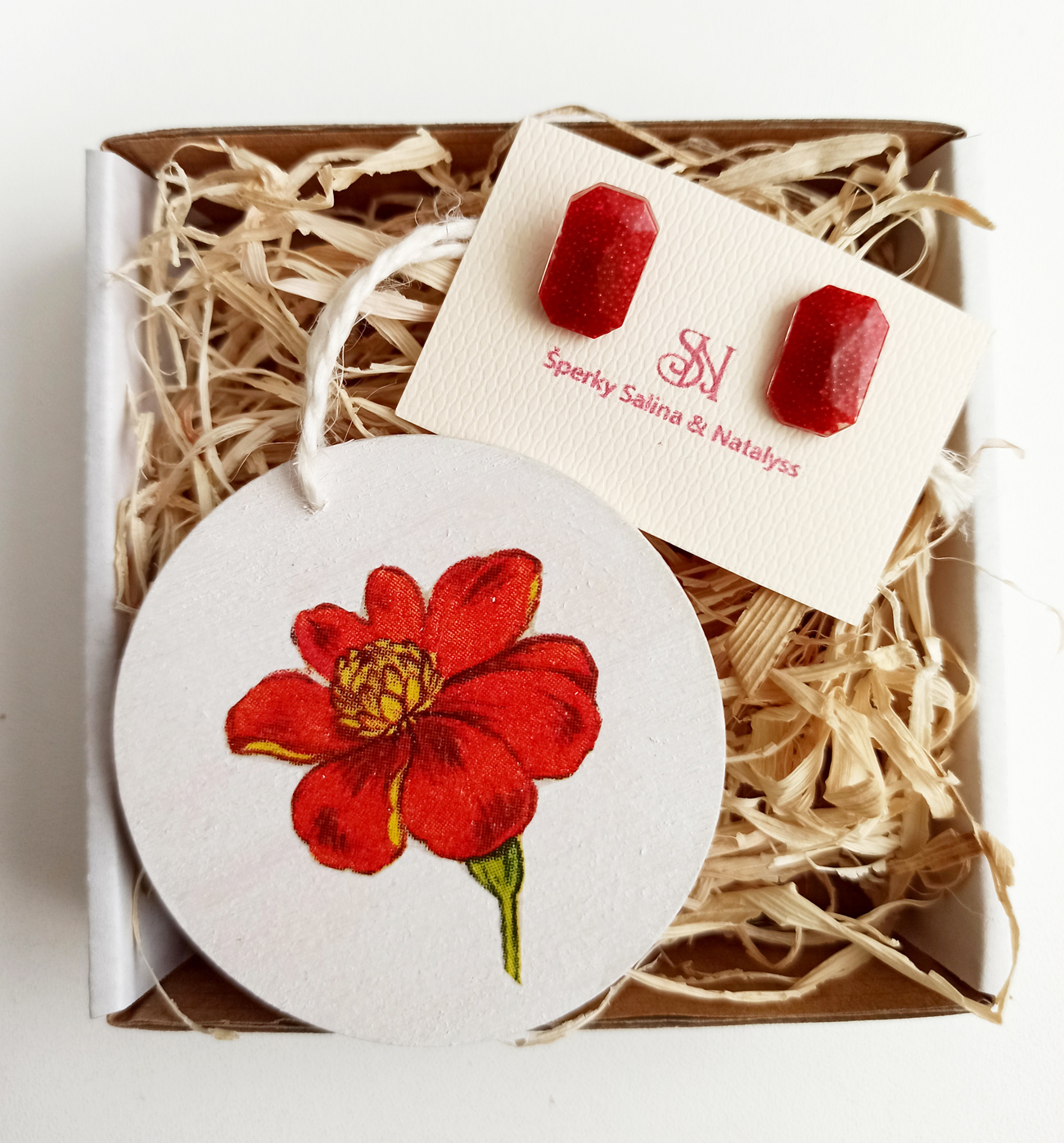 Malý červený darčekový box s náušnicami a dekoráciou 